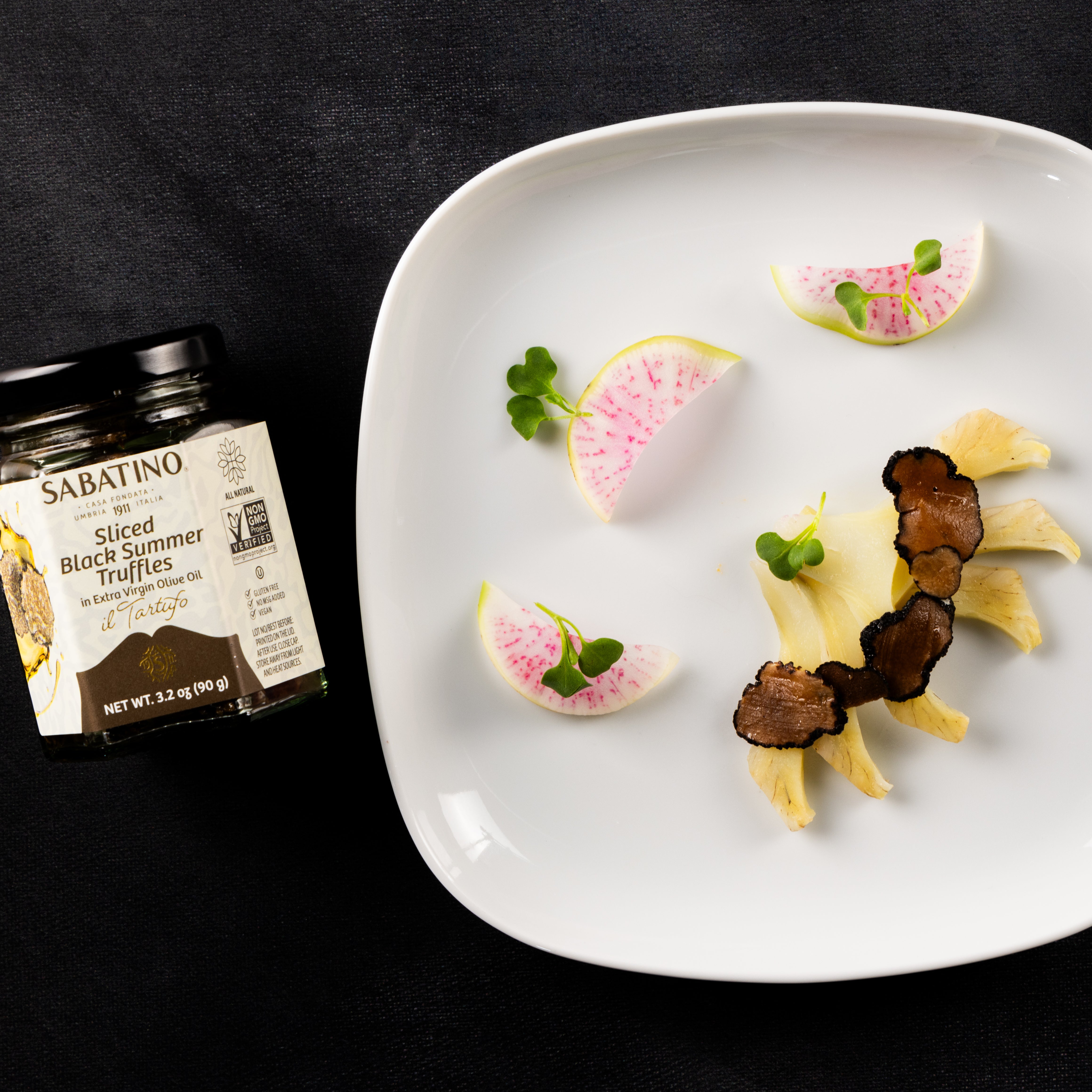 a plate of food and a jar of black summer truffles