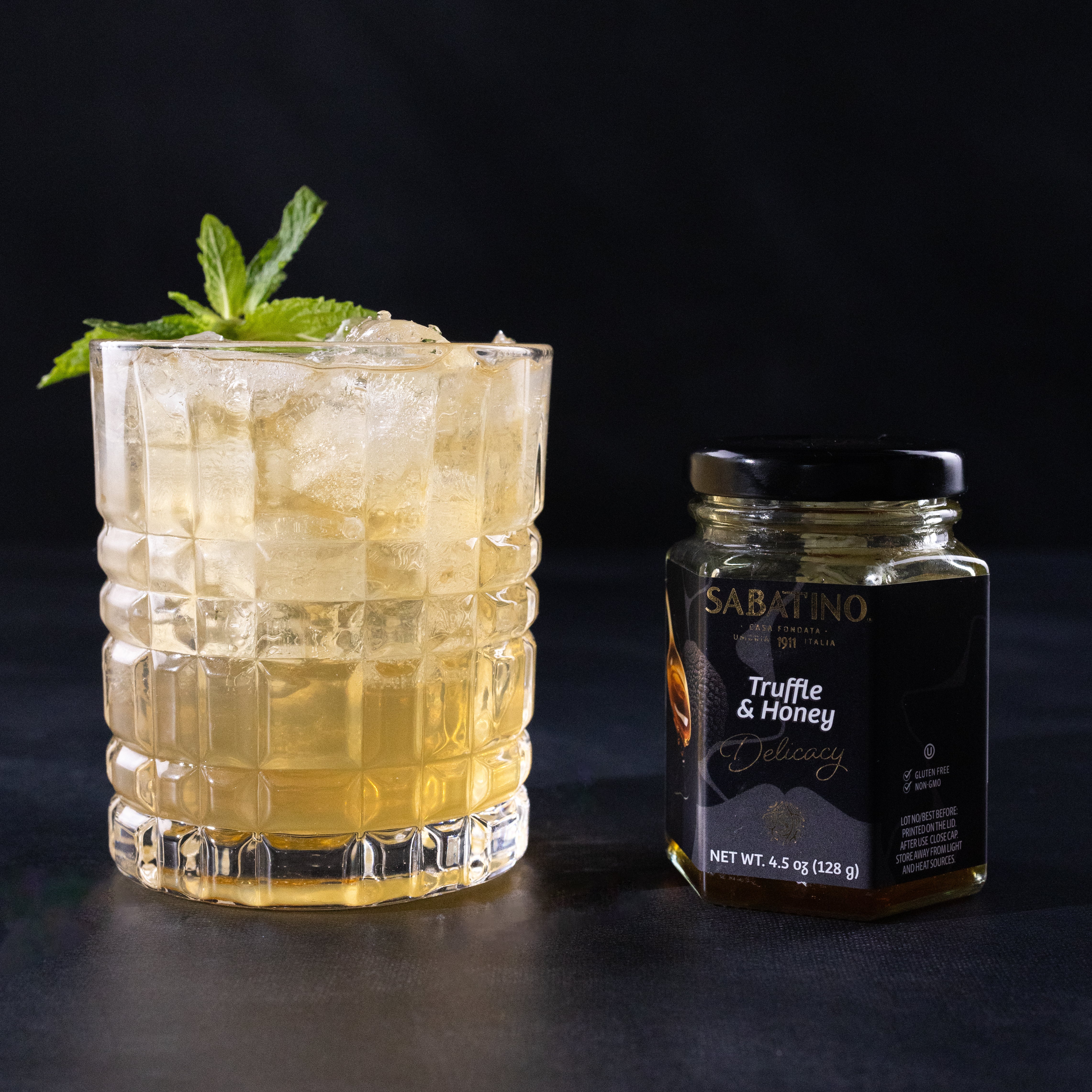 a glass of ice tea and a jar of honey