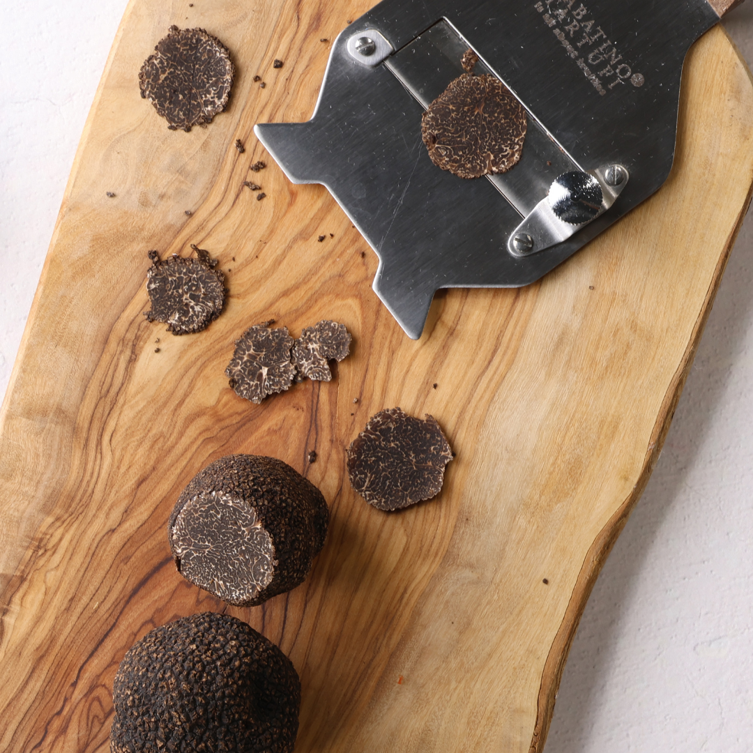 a slicer and round brown objects on a wooden board