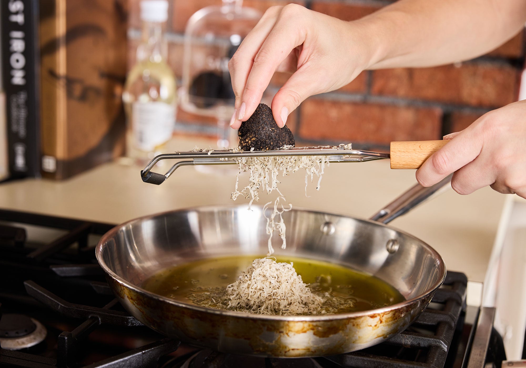 a person holding a piece of food over a pan of food