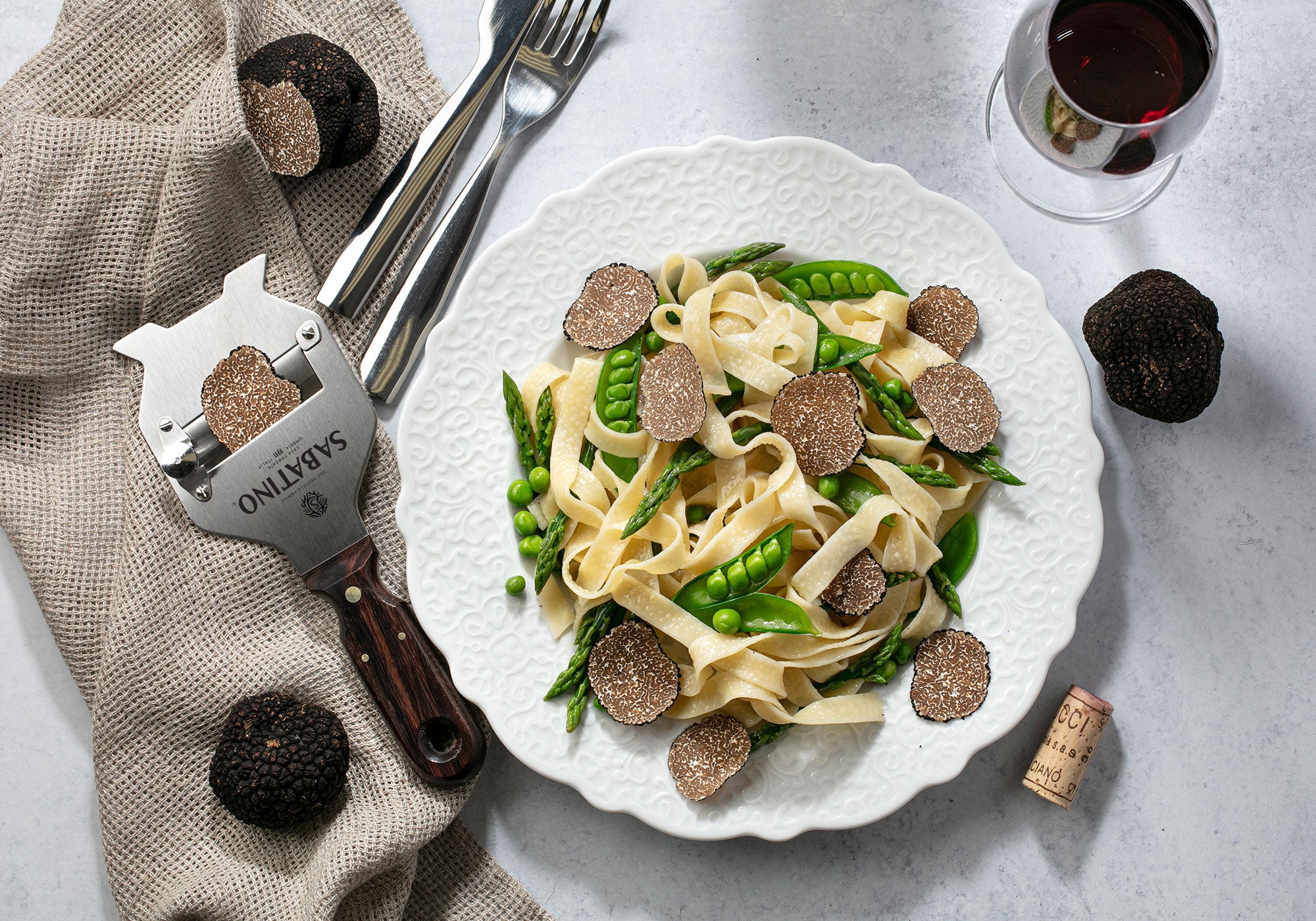 a plate of pasta with vegetables and a corkscrew
