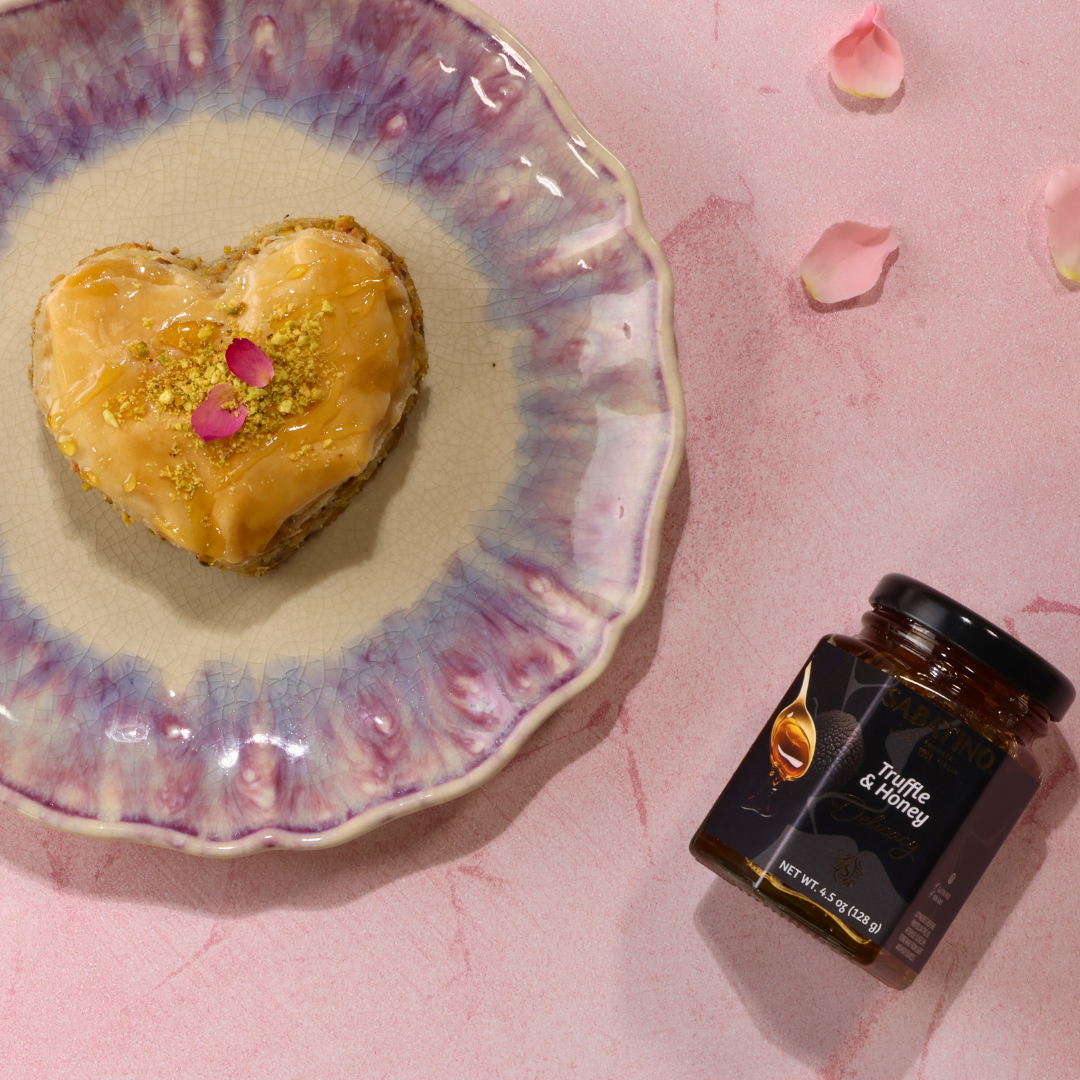 a heart shaped pastry on a plate next to a jar of jam