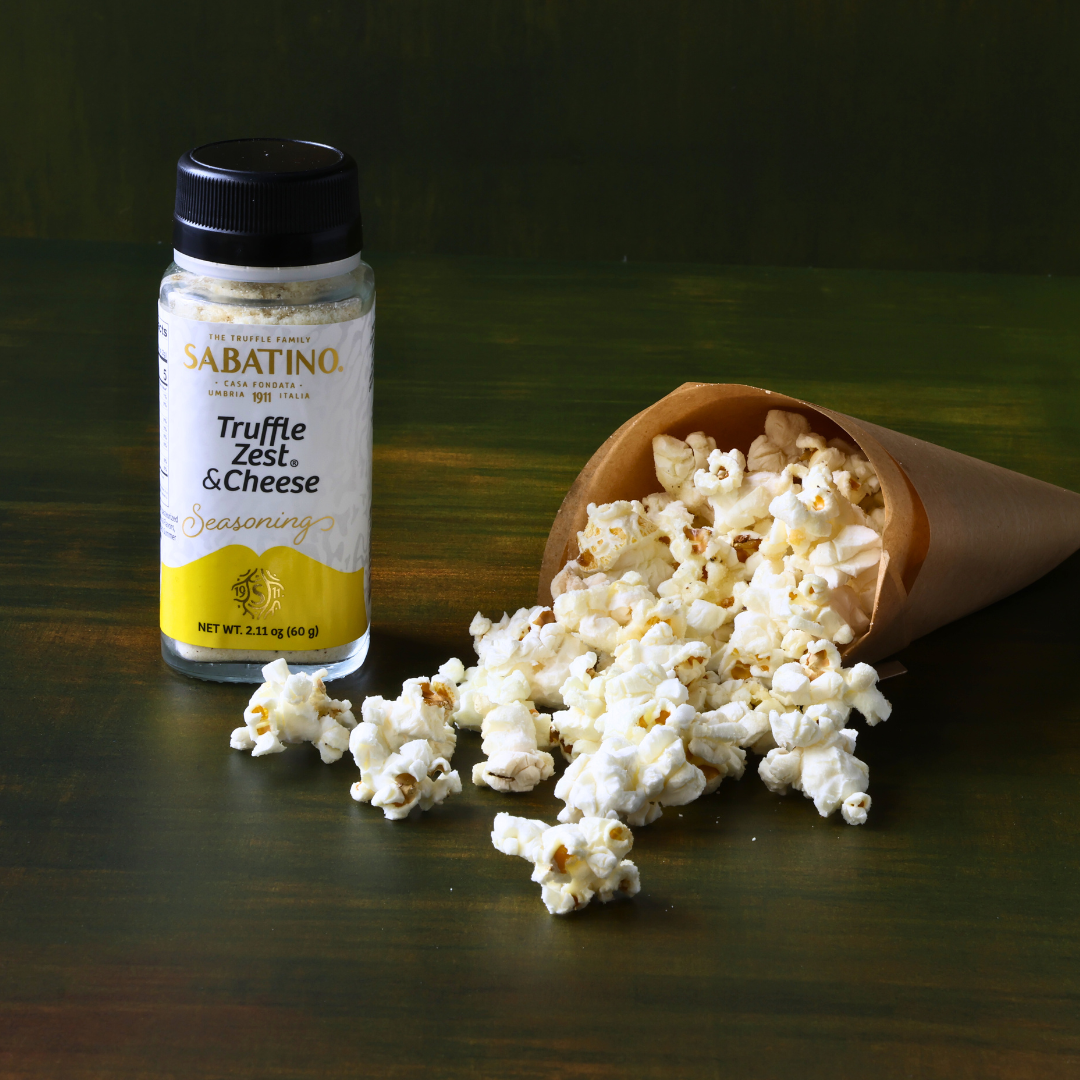a popcorn in a cone next to a bottle of seasoning