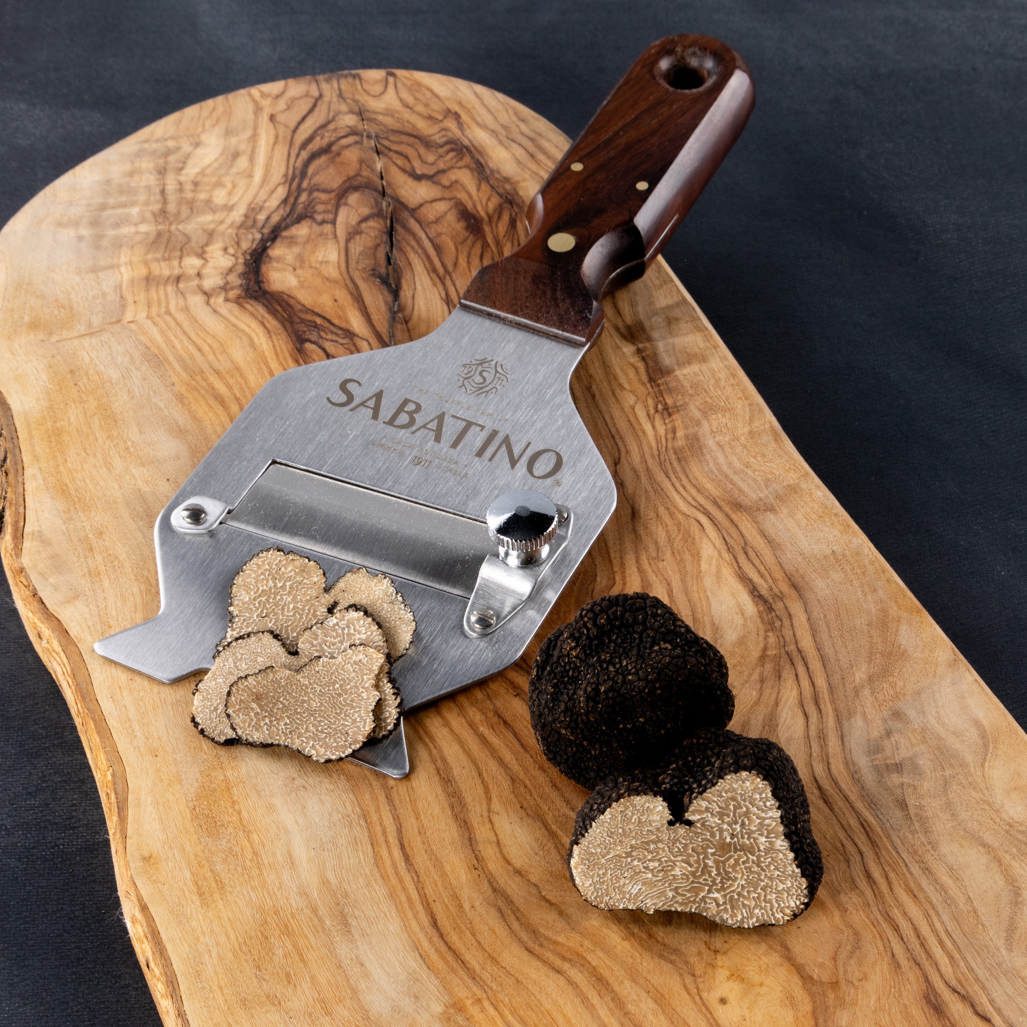 a slicer with a slicer and black truffles on a cutting board