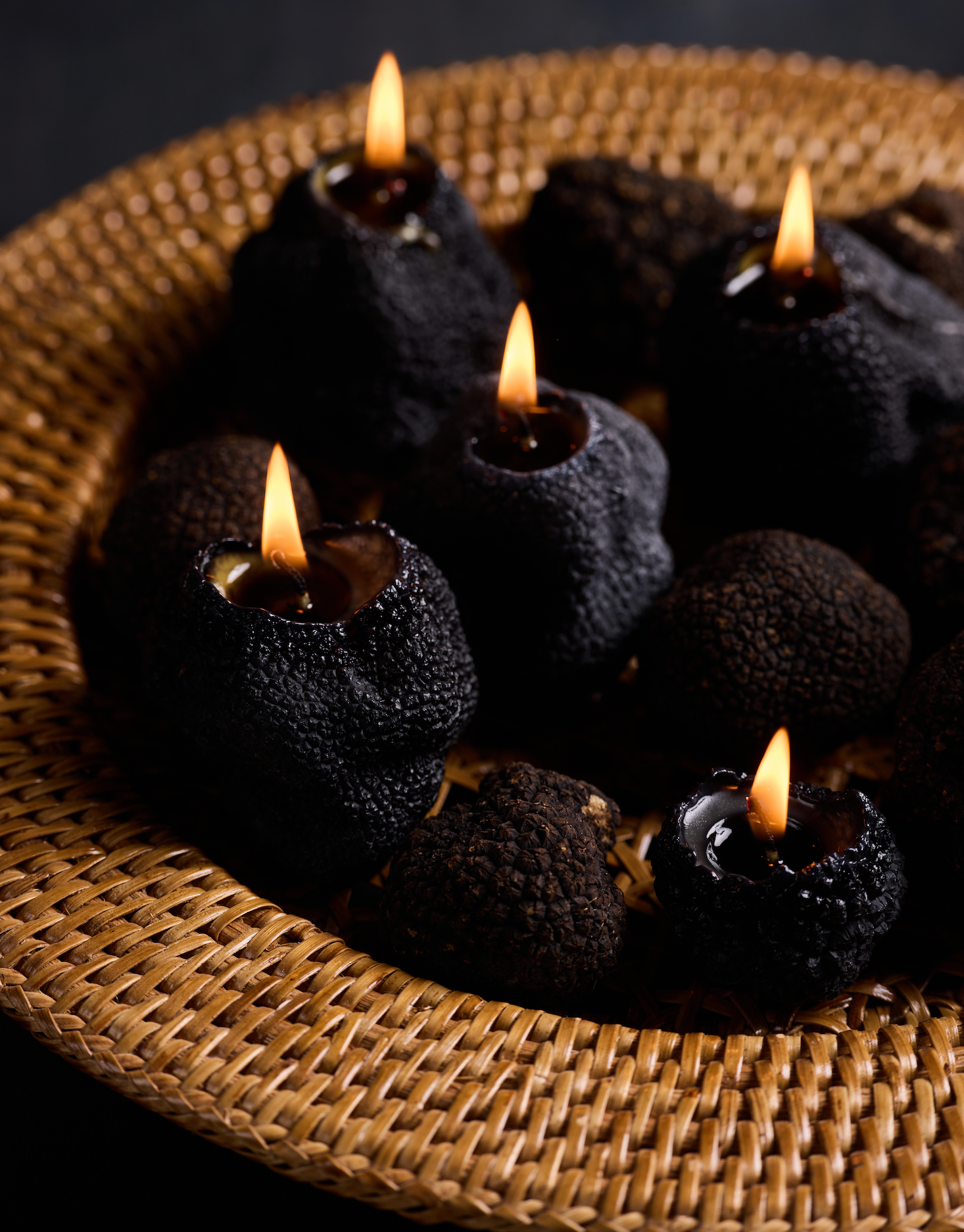 a group of black candles in a basket